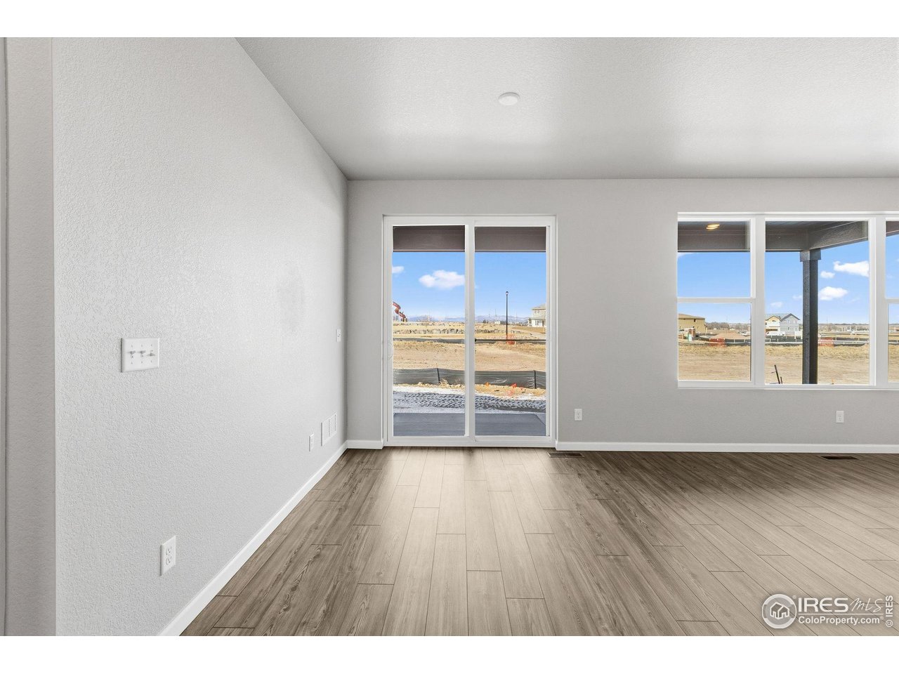 6793 Utica Court Firestone, CO 80504 - Photo 12 of 26 a view of an empty room with wooden floor and a window