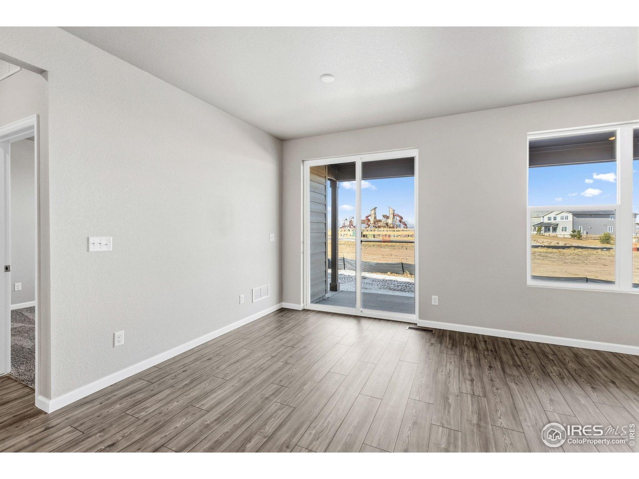 6793 Utica Court Firestone, CO 80504 - Photo 13 of 26 a view of an empty room with window and wooden floor