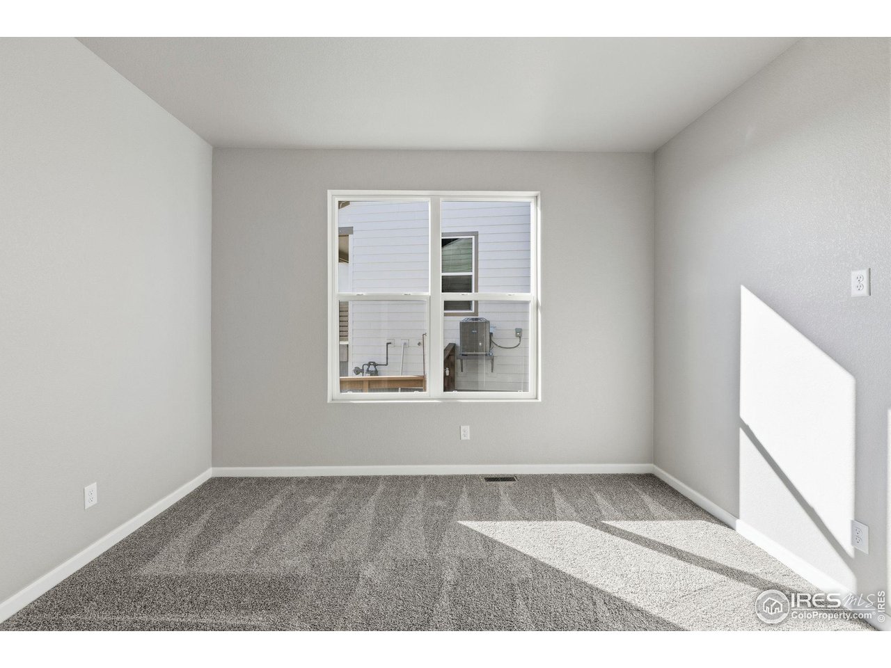 6793 Utica Court Firestone, CO 80504 - Photo 4 of 26 a view of an empty room with wooden floor and a window