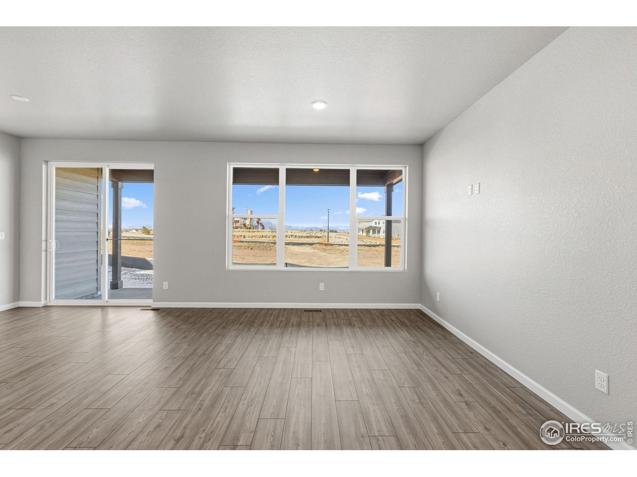 6793 Utica Court Firestone, CO 80504 - Photo 10 of 26 a view of an empty room with wooden floor and a window