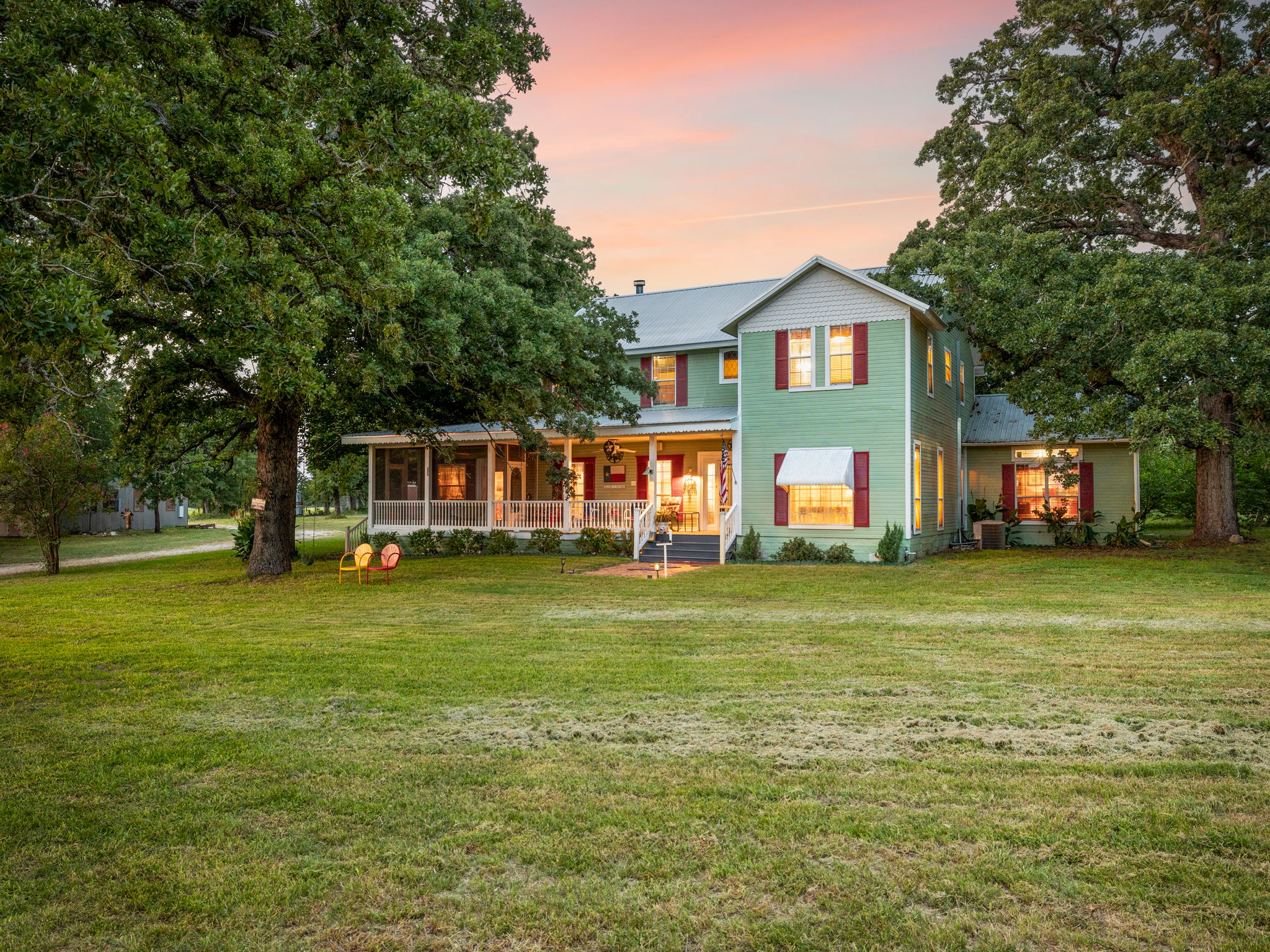 Evening view of the home showcasing a large fenced yard that offers privacy and the perfect setting to enjoy beautiful sunsets.