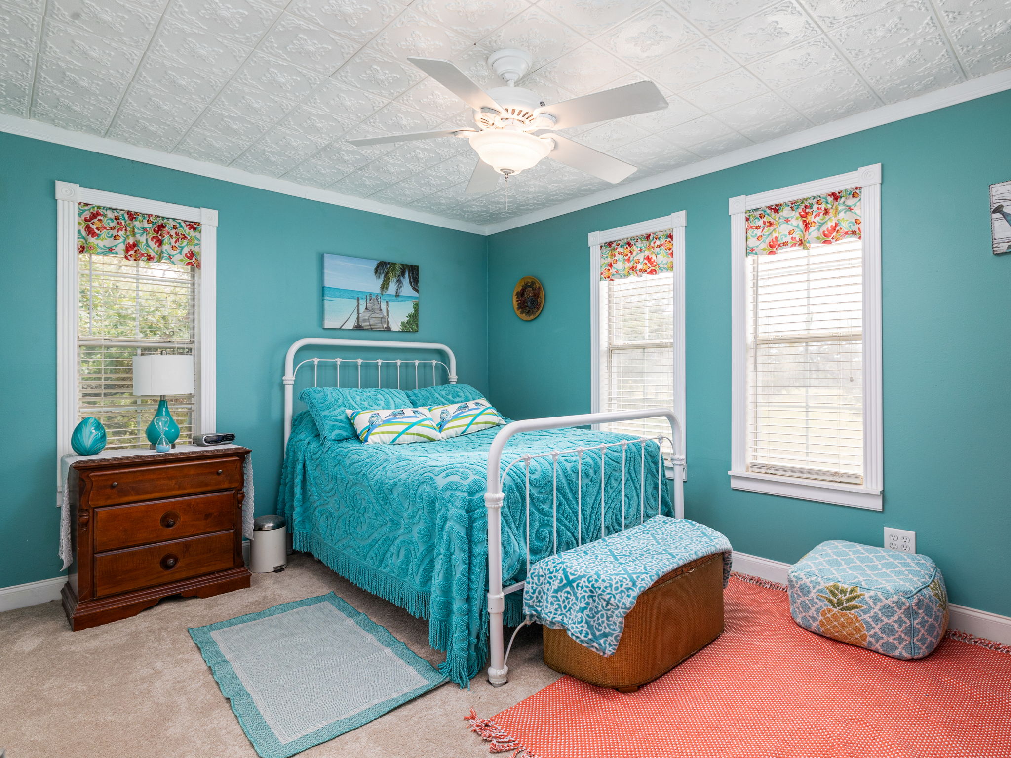 1065 Private Road 7041 Elgin, TX 78621 - Photo 20 of 38 Bedroom featuring elegant crown molding and an ornate, detailed vintage tin ceiling. Soft carpet floors, a ceiling fan, and abundant natural light create a bright and comfortable retreat