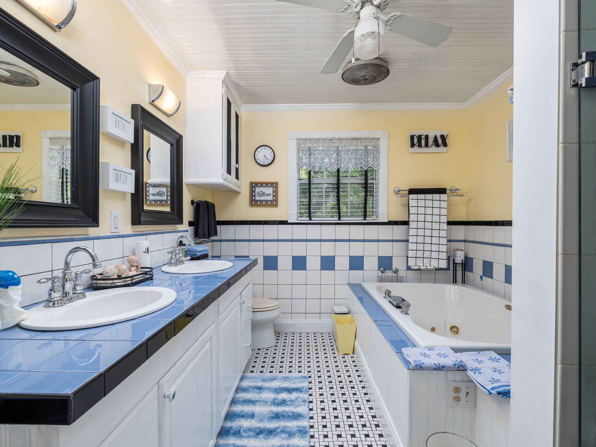 1065 Private Road 7041 Elgin, TX 78621 - Photo 21 of 38 ull bathroom showcasing elegant crown molding and an ornate, detailed ceiling. Features include a double vanity with tiled countertops, tiled walls and flooring, a Jacuzzi tub for relaxing soaks, a separate walk-in shower, and a ceiling fan for added comfort
