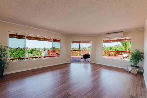 an empty room with large window and wooden floor