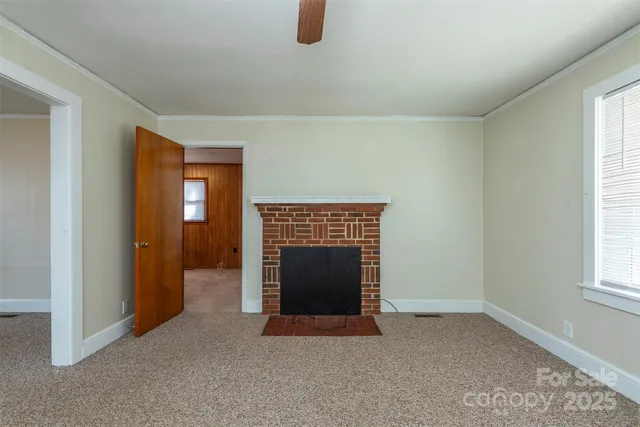 an empty room with windows and fireplace