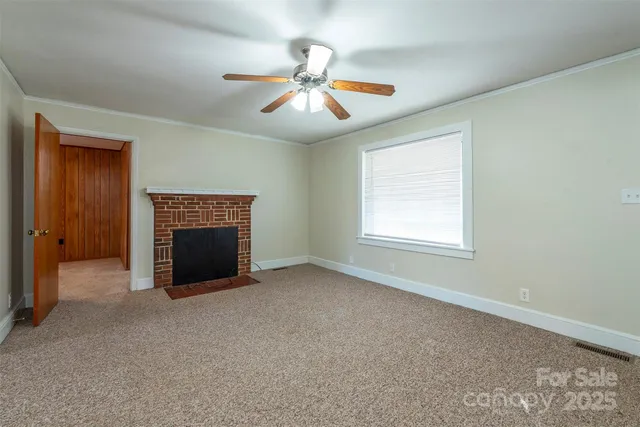an empty room with windows and fireplace