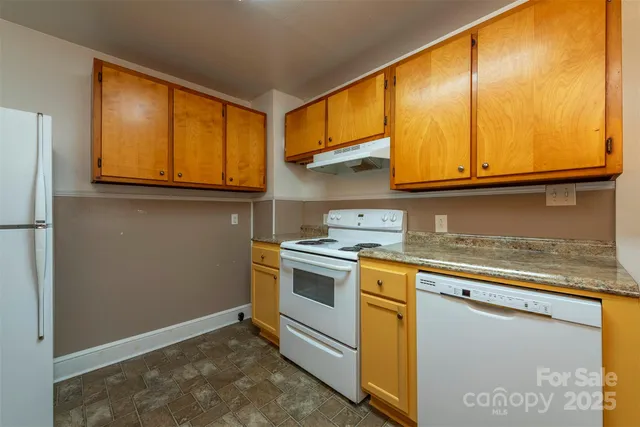 a kitchen with stainless steel appliances granite countertop a sink a stove and a refrigerator