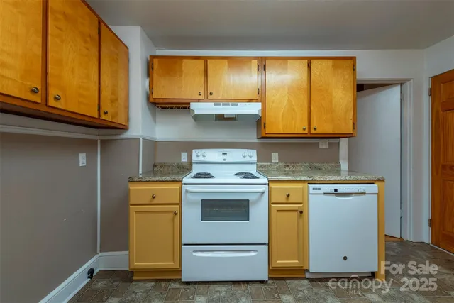 a kitchen with a stove top oven cabinets and a window