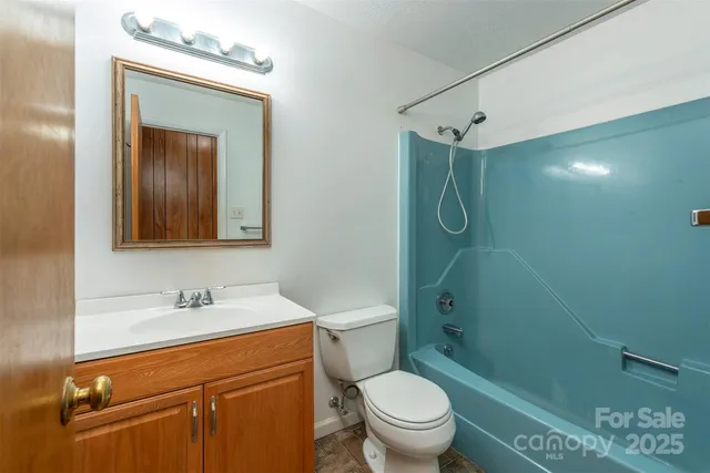 a bathroom with a granite countertop sink toilet and shower