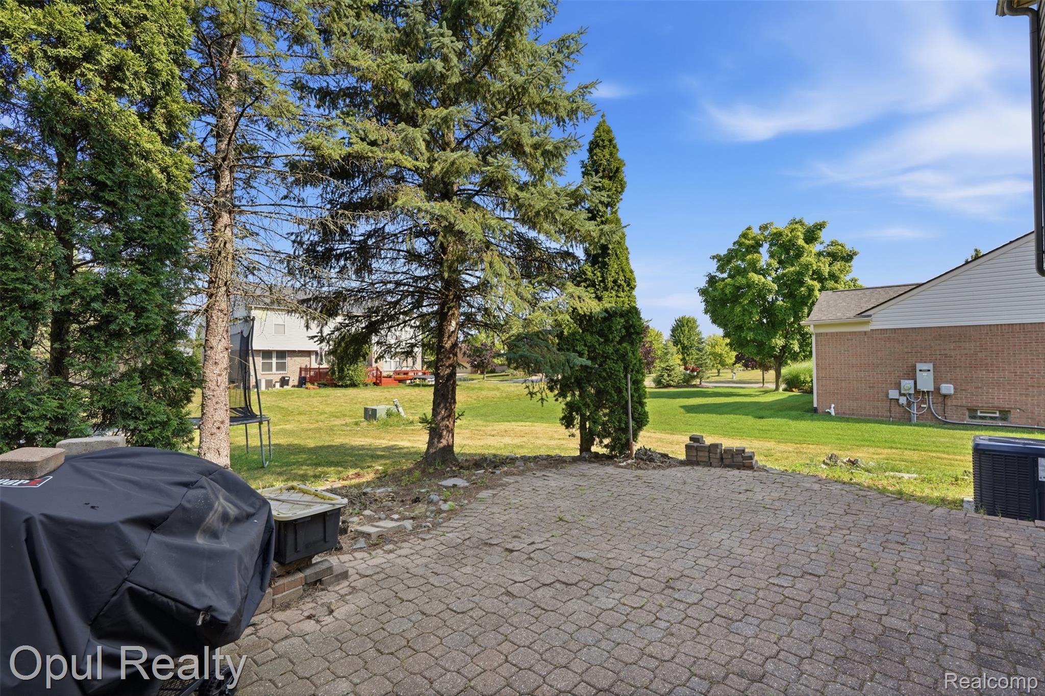 4530 Pond Run Canton, MI 48188 - Photo 41 of 43 Paver patio space extending to a grassy yard with mature trees