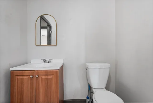 a bathroom with a toilet sink and mirror
