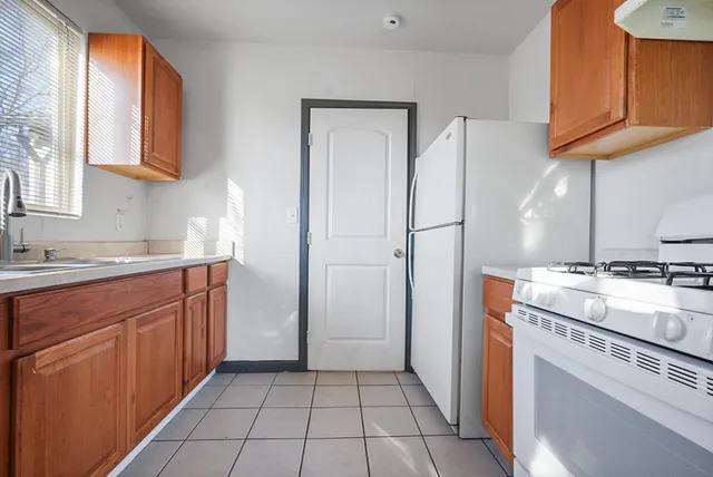 a kitchen with a refrigerator sink and cabinets