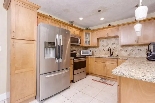 a kitchen with a refrigerator a sink and cabinets