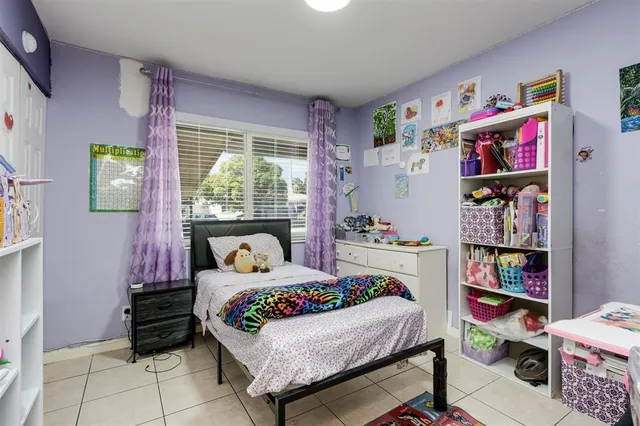 a bedroom with a bed a dresser and book shelf