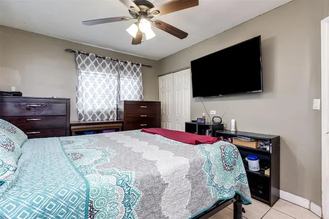 a bed room with a bed a flat screen tv and a dresser