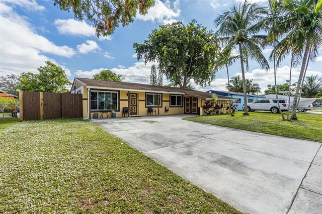 a front view of a house with garden and trees