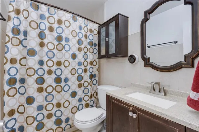 a bathroom with a granite countertop sink a toilet and a mirror