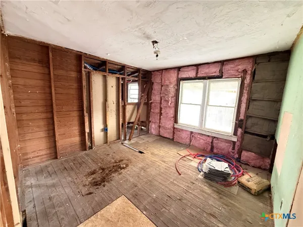 an empty room with a fireplace and window