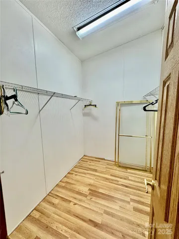 a view of an empty room with kitchen and a window