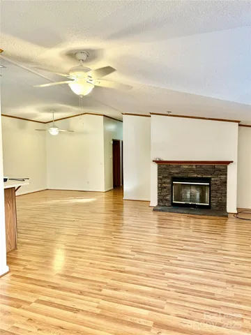 a view of an empty room with wooden floor and windows