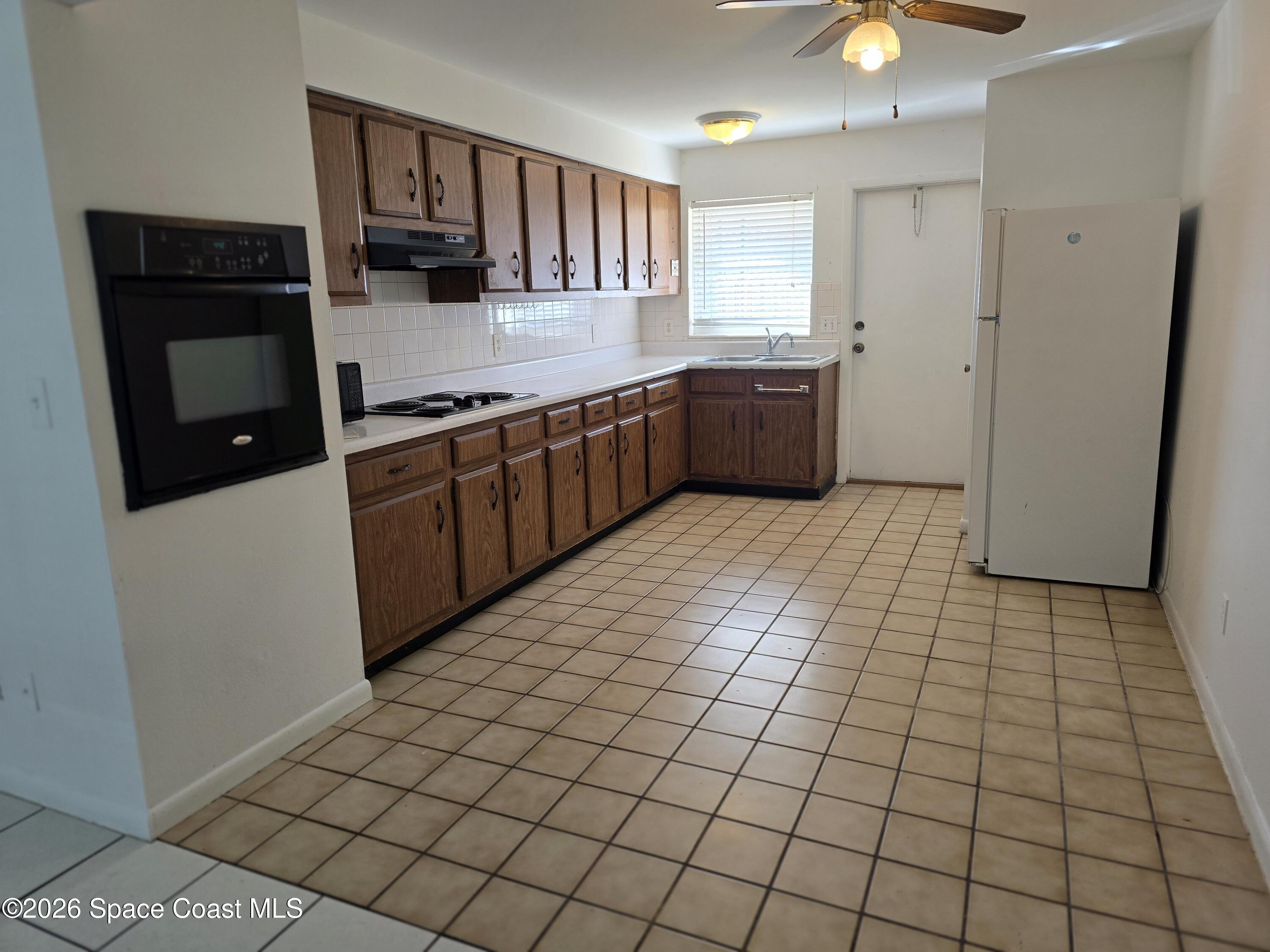 95 Lucas Road Merritt Island, FL 32953 - Photo 4 of 7 a kitchen with stainless steel appliances a sink and cabinets