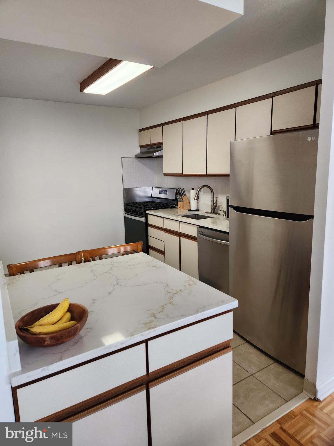 3900 West Ford Road, Unit 12A Philadelphia, PA 19131 - Photo 14 of 46 a kitchen with stainless steel appliances granite countertop a refrigerator sink stove and white cabinets