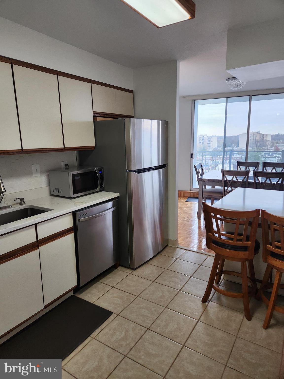 3900 West Ford Road, Unit 12A Philadelphia, PA 19131 - Photo 18 of 46 a kitchen with a sink a refrigerator and chairs