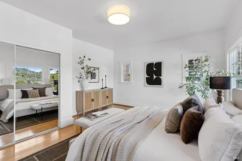 a bedroom with a bed and large windows