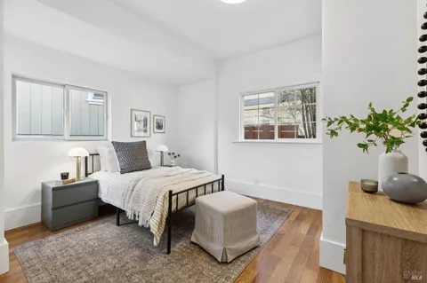 a bedroom with a bed potted plant with the wooden floor