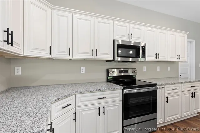 a view of a kitchen with a fireplace a ceiling fan and wooden floor