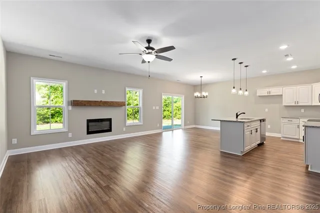 a view of a livingroom with a fireplace wooden floor and chandelier