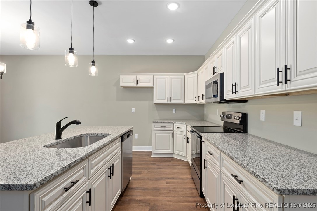 5578 Philippi Church Road Raeford, NC 28376 - Photo 20 of 33 a kitchen with kitchen island granite countertop a sink a counter space appliances and cabinets