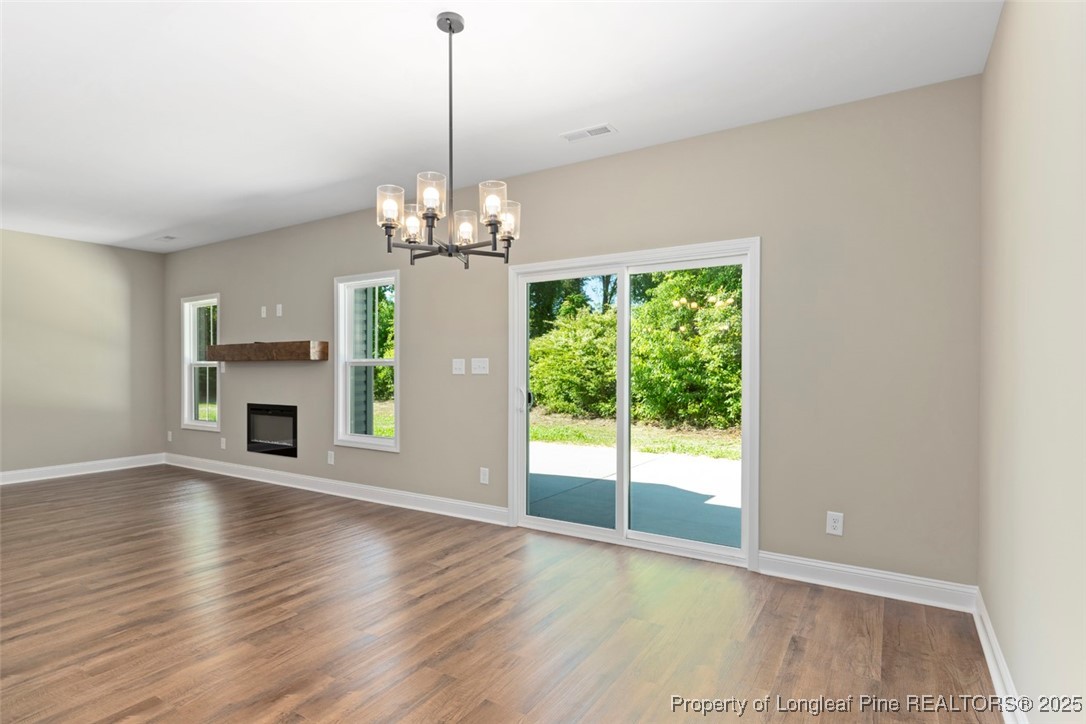 5578 Philippi Church Road Raeford, NC 28376 - Photo 23 of 33 a view of a livingroom with a fireplace wooden floor and chandelier