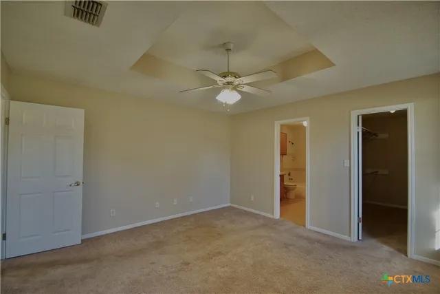 an empty room with a ceiling fan and a window