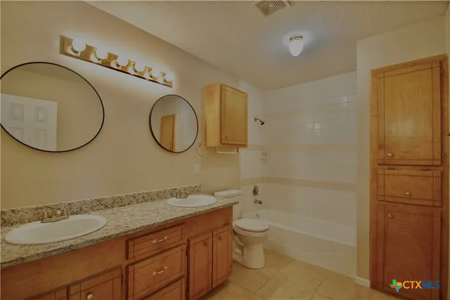 a bathroom with a double vanity sink and a mirror