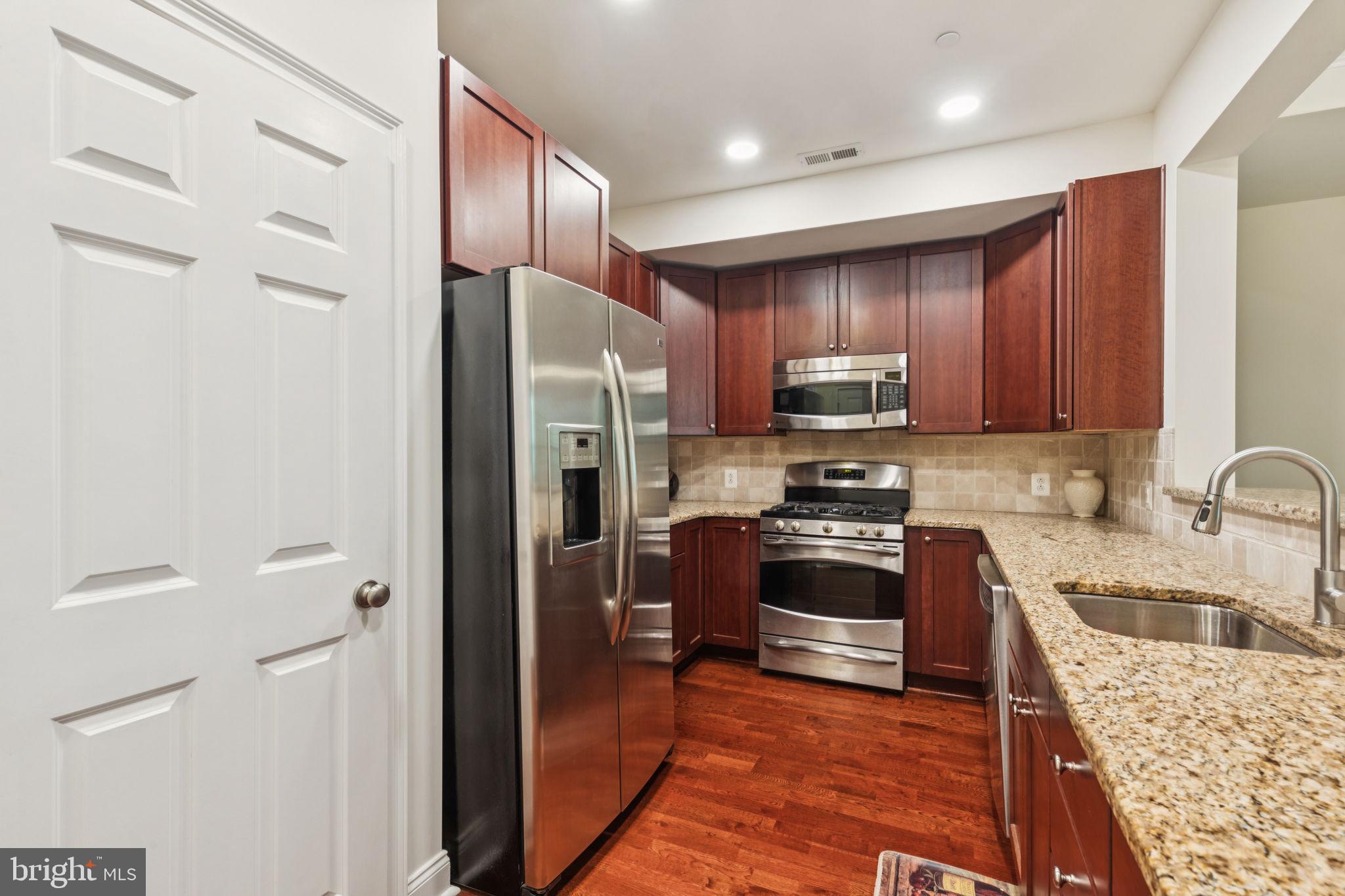 105 Commodore Court Philadelphia, PA 19146 - Photo 6 of 26 a kitchen with granite countertop a refrigerator and a stove top oven