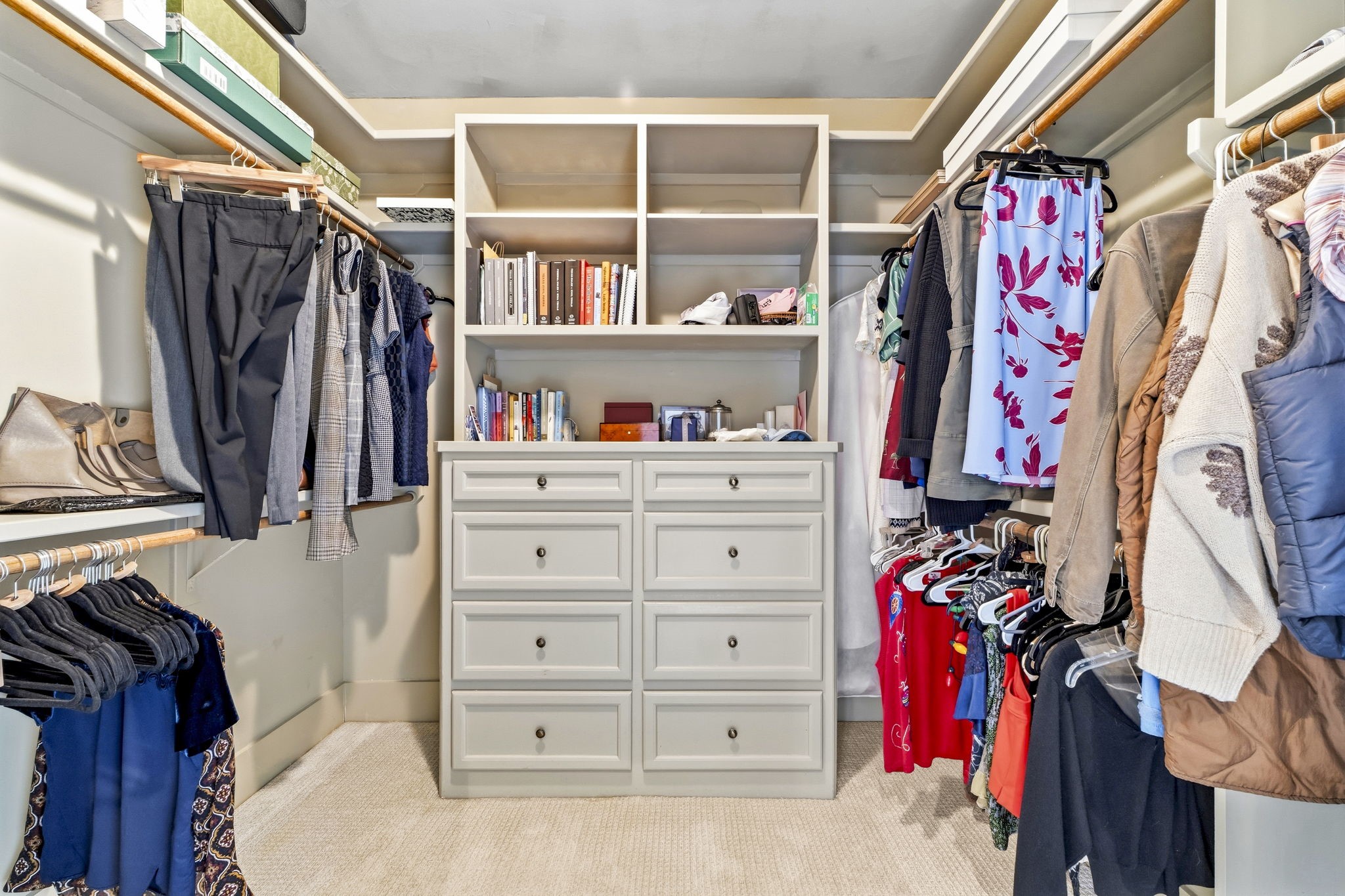1521 Kipling Street Houston, TX 77006 - Photo 26 of 35 This photo showcases a spacious walk-in closet featuring ample hanging space, built-in shelving, and a central dresser unit, ideal for organized storage.