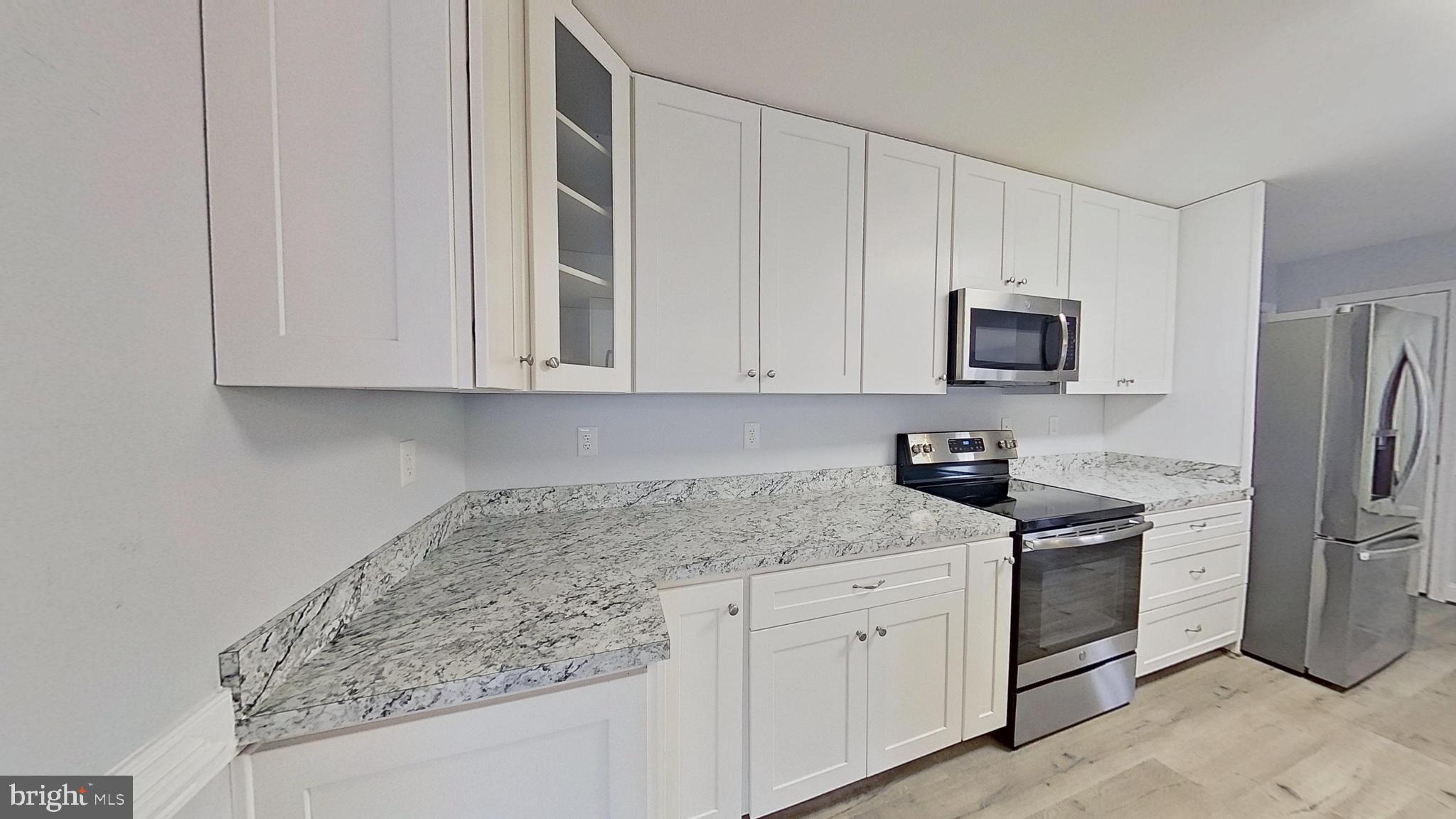 95 Rolando Drive Colonial Beach, VA 22443 - Photo 15 of 39 a kitchen with stainless steel appliances granite countertop white cabinets a refrigerator and a sink