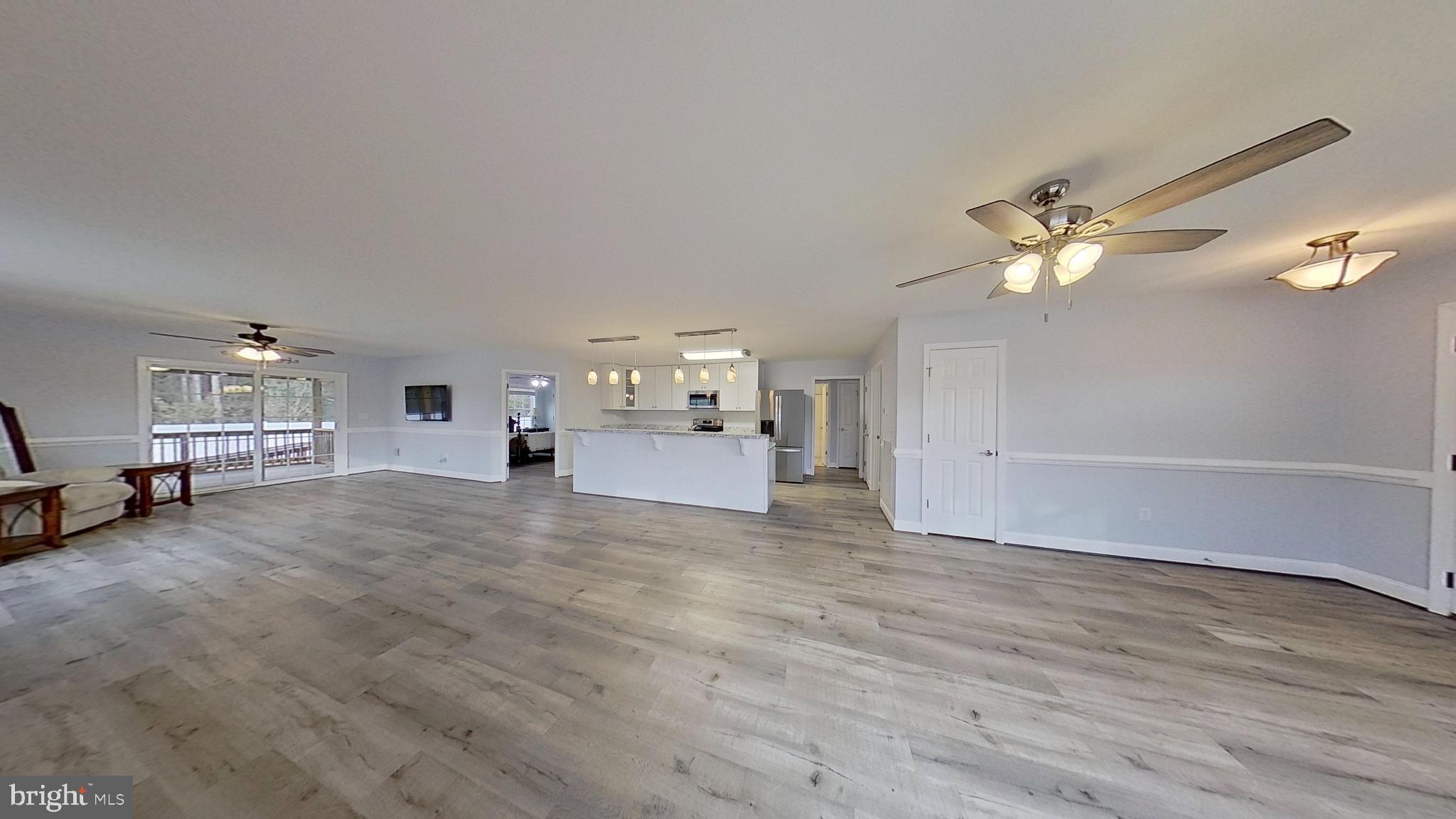 95 Rolando Drive Colonial Beach, VA 22443 - Photo 21 of 39 a view of a livingroom with a ceiling fan a fireplace and wooden floor