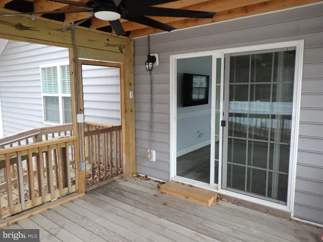 a view of an empty room with wooden floor and windows