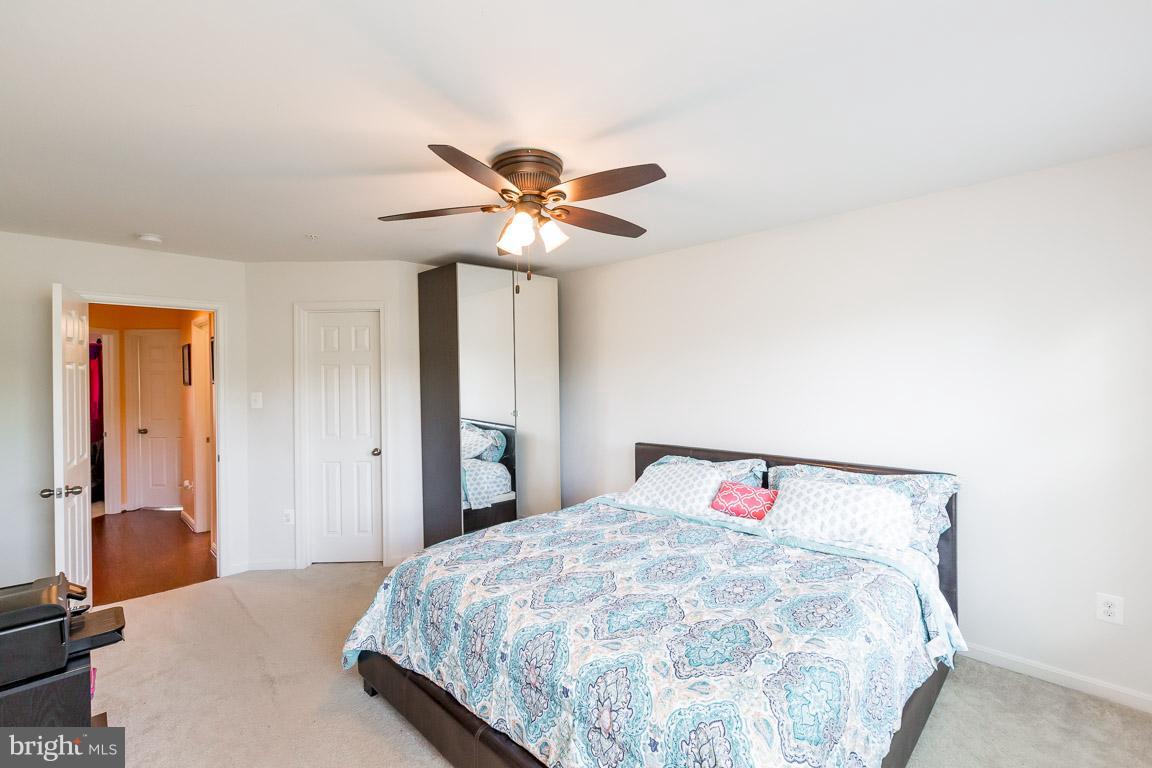 8042 Wright Place, Unit 103 Jessup, MD 20794 - Photo 13 of 22 a bedroom with a bed and a chandelier