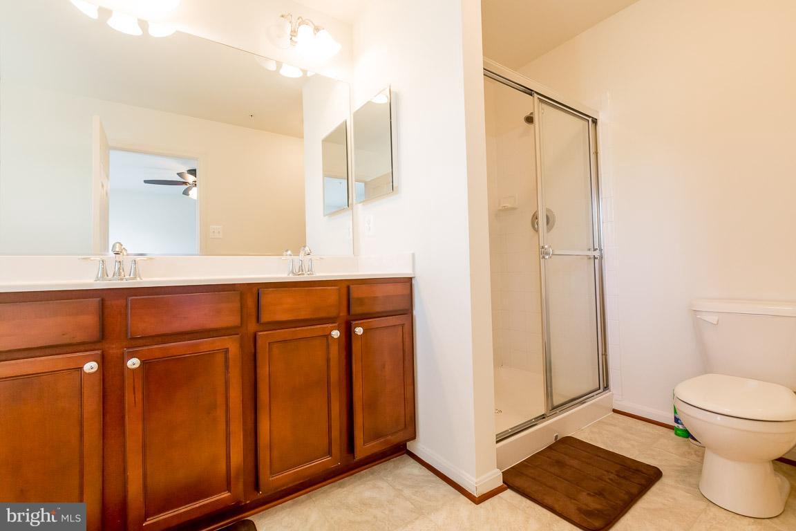 8042 Wright Place, Unit 103 Jessup, MD 20794 - Photo 14 of 22 a bathroom with a toilet a sink and a mirror