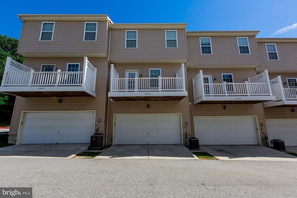 8042 Wright Place, Unit 103 Jessup, MD 20794 - Photo 22 of 22 a front view of a house with a parking space and a garage