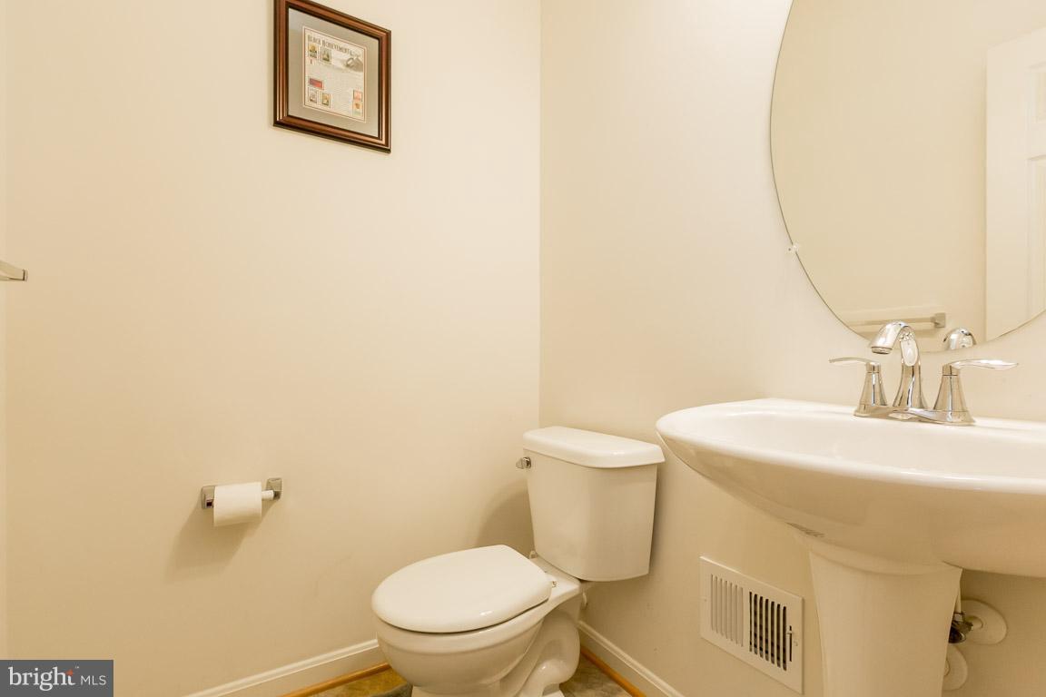 8042 Wright Place, Unit 103 Jessup, MD 20794 - Photo 5 of 22 a white toilet sitting next to a bathroom sink