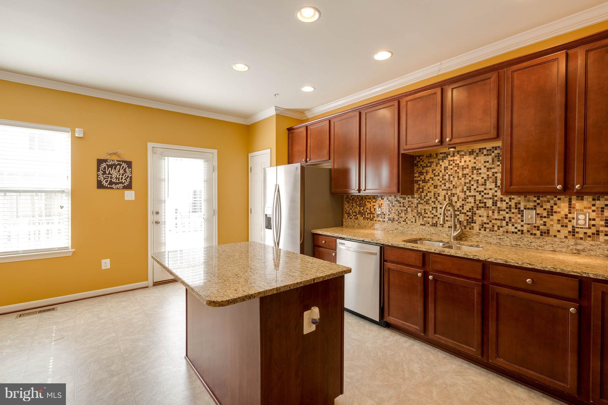 8042 Wright Place, Unit 103 Jessup, MD 20794 - Photo 8 of 22 a kitchen with stainless steel appliances granite countertop wooden cabinets a sink and dishwasher