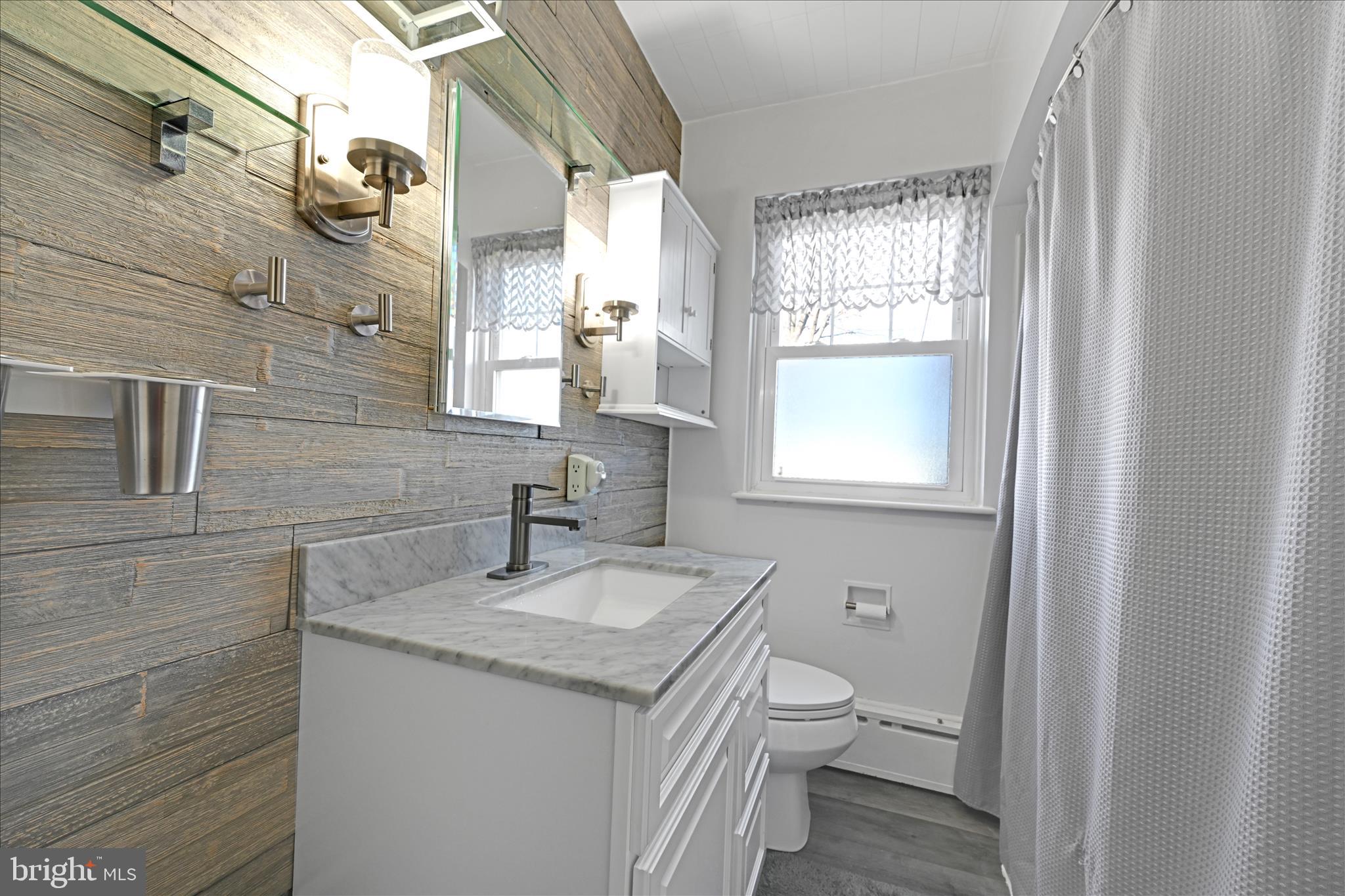 401 Park Road Fleetwood, PA 19522 - Photo 30 of 47 a bathroom with a granite countertop toilet a sink and a mirror