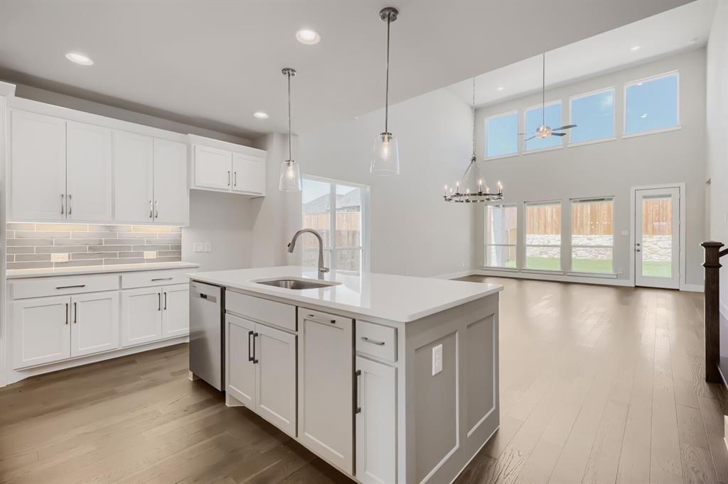 4407 Windy Point Road Oak Point, TX 75068 - Photo 6 of 27 Open-concept living space with a kitchen island featuring a stainless steel sink and pendant lighting