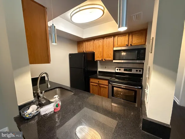 a kitchen with stainless steel appliances a stove a refrigerator and a sink