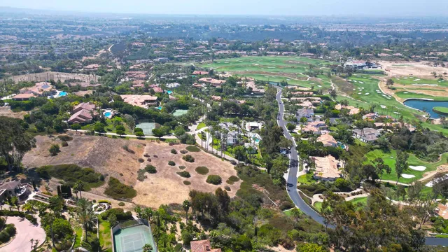 an aerial view of residential houses with outdoor space and trees