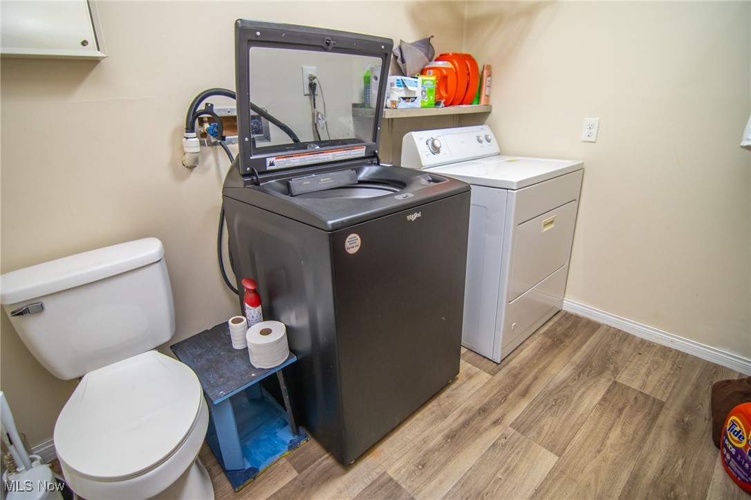 54899 National Road Bridgeport, OH 43912 - Photo 16 of 22 Clothes washing area featuring separate washer and dryer, light wood-style flooring, and baseboards